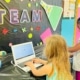 two kids making art with colored cut-outs on a table