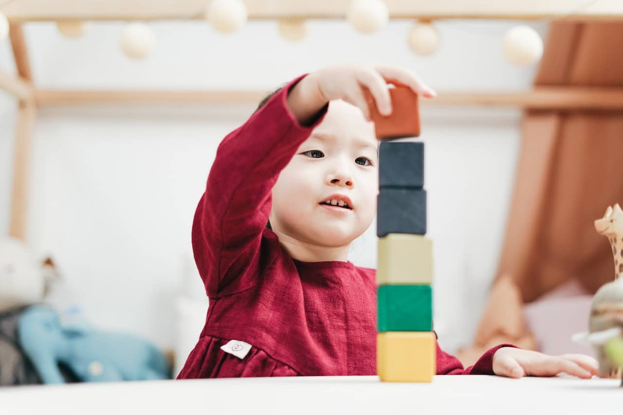 a young girl playing with blocks