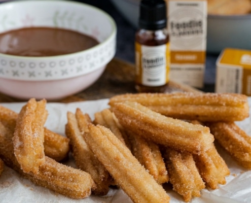 Churros on a paper towel and chocolate sauce on the side