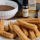 Churros on a paper towel and chocolate sauce on the side