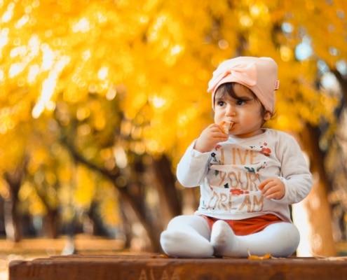 young girl sitting on a table in autumn
