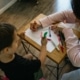 little boy coloring with his mom