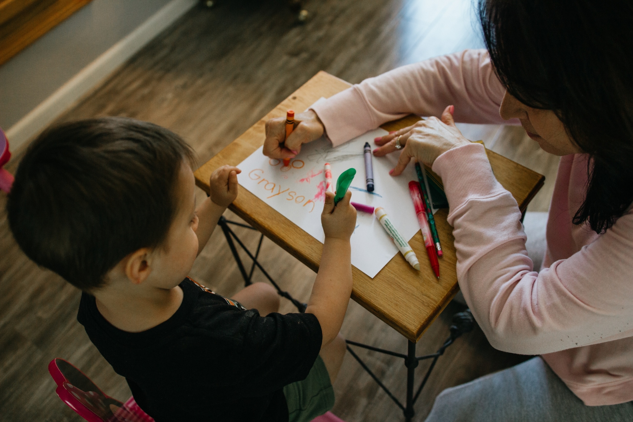 little boy coloring with his mom