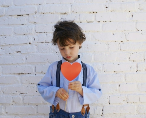 young boy holding a paper heart