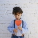 young boy holding a paper heart