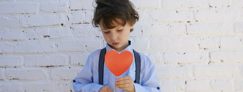young boy holding a paper heart
