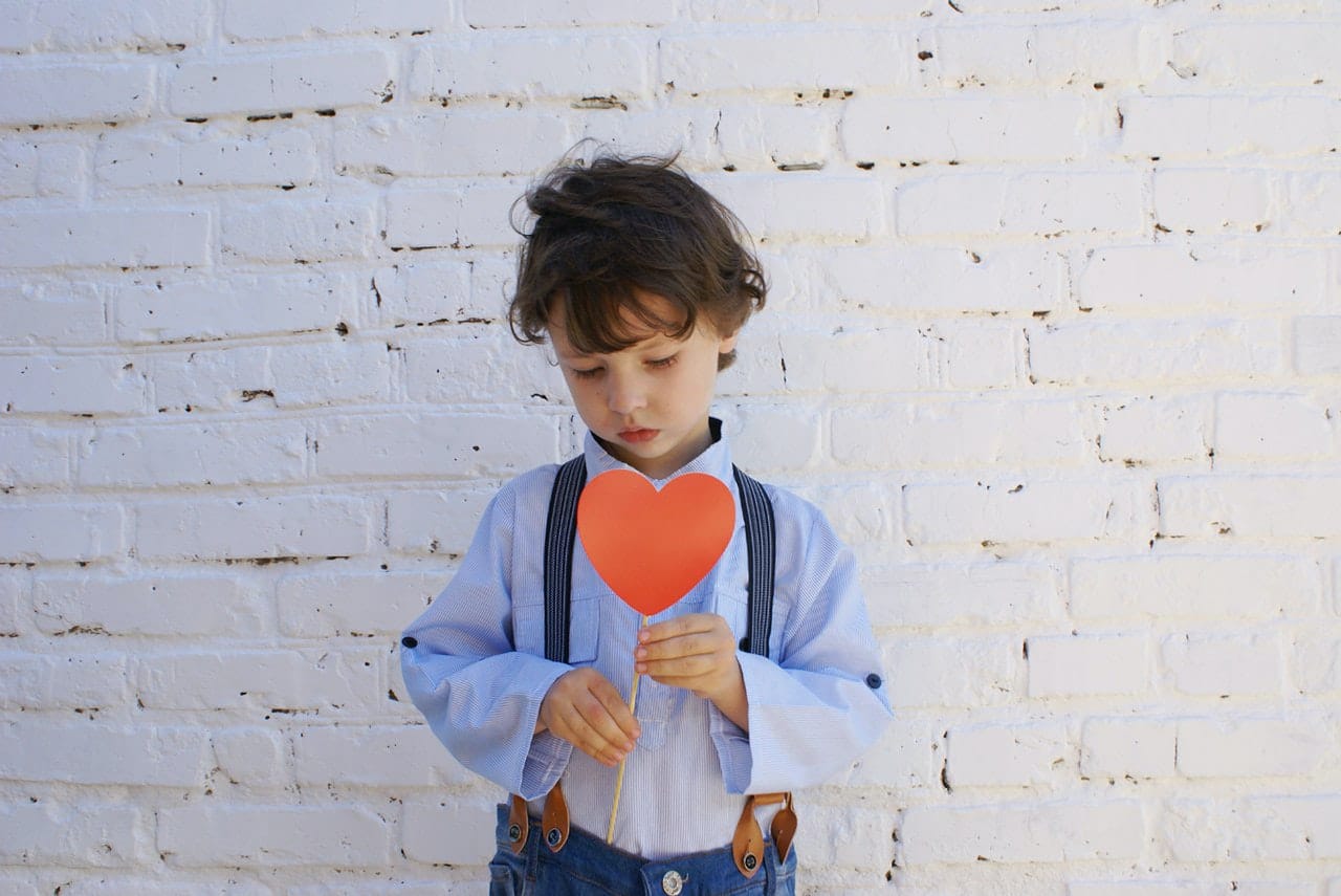 young boy holding a paper heart