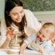 mother playing wooden toy with her baby