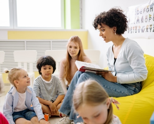 teacher reading a book to students
