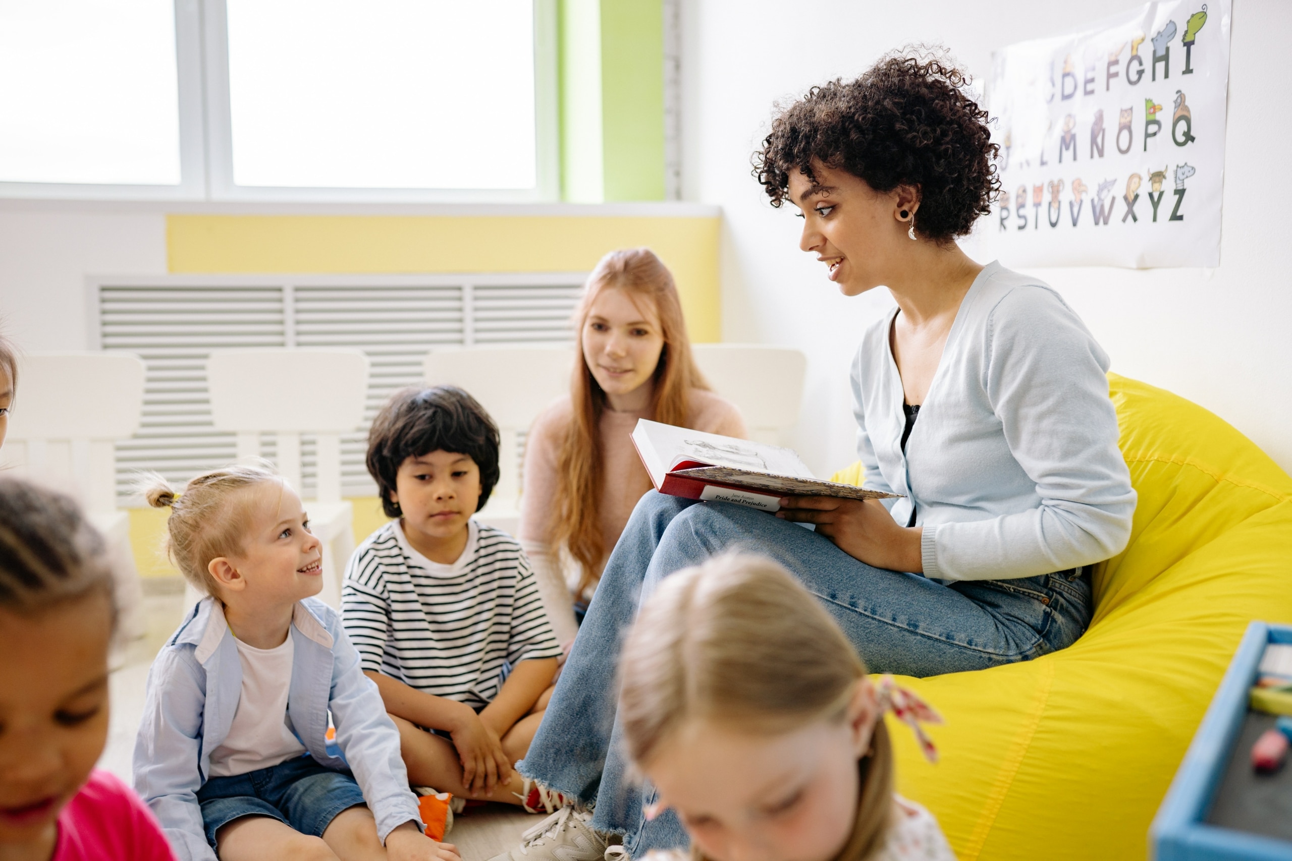 teacher reading a book to students