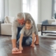 father and son fun cleaning the floor