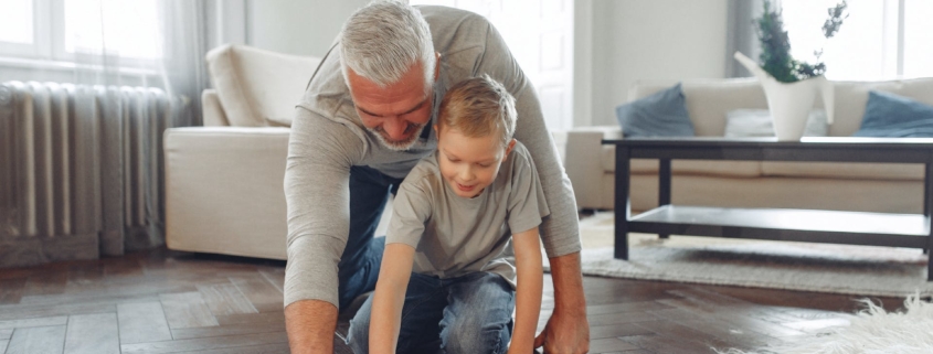 father and son fun cleaning the floor