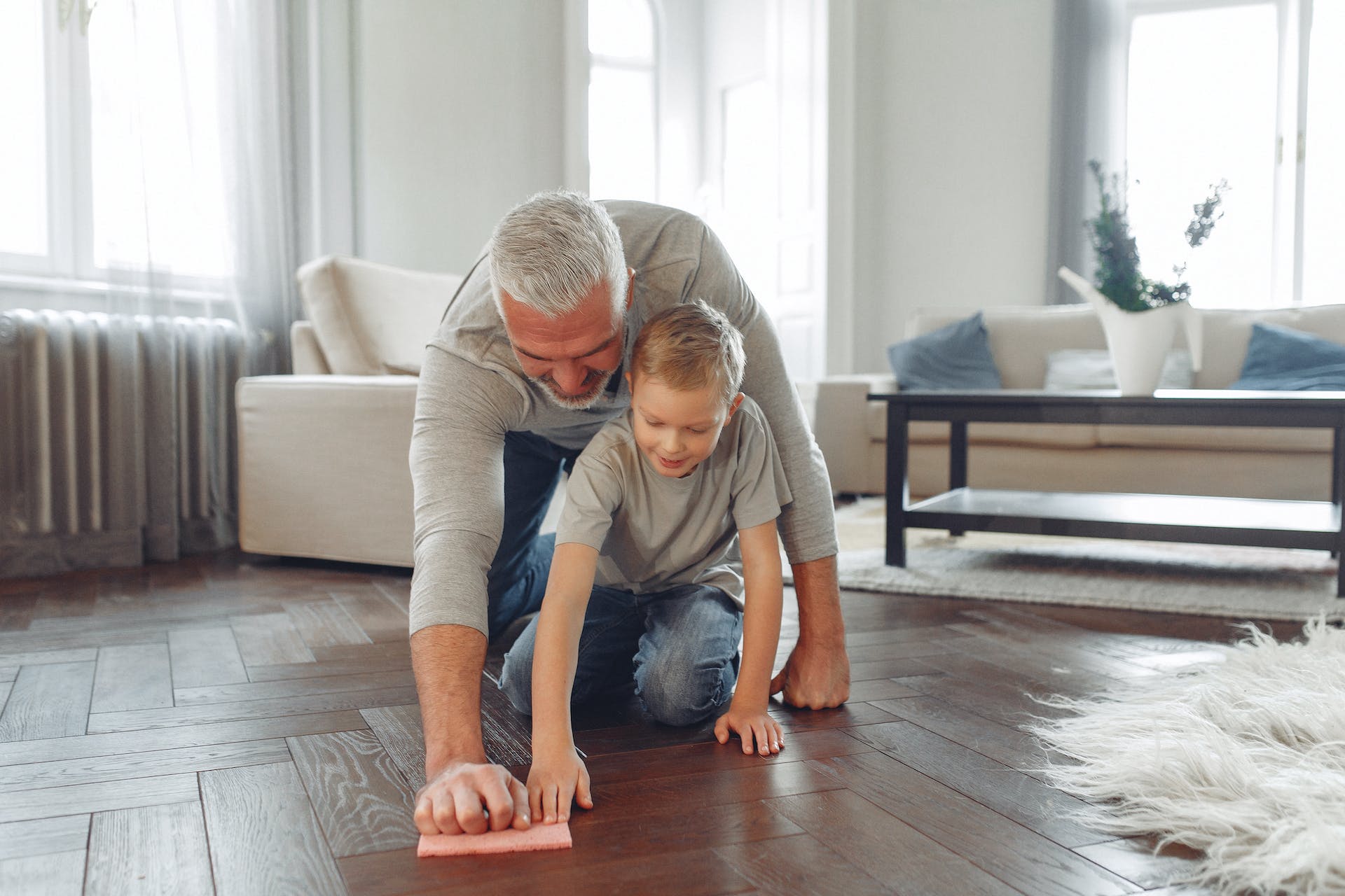 father and son fun cleaning the floor