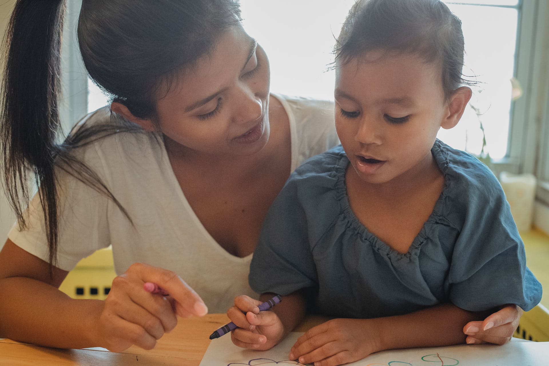 Mother and daughter drawing at home