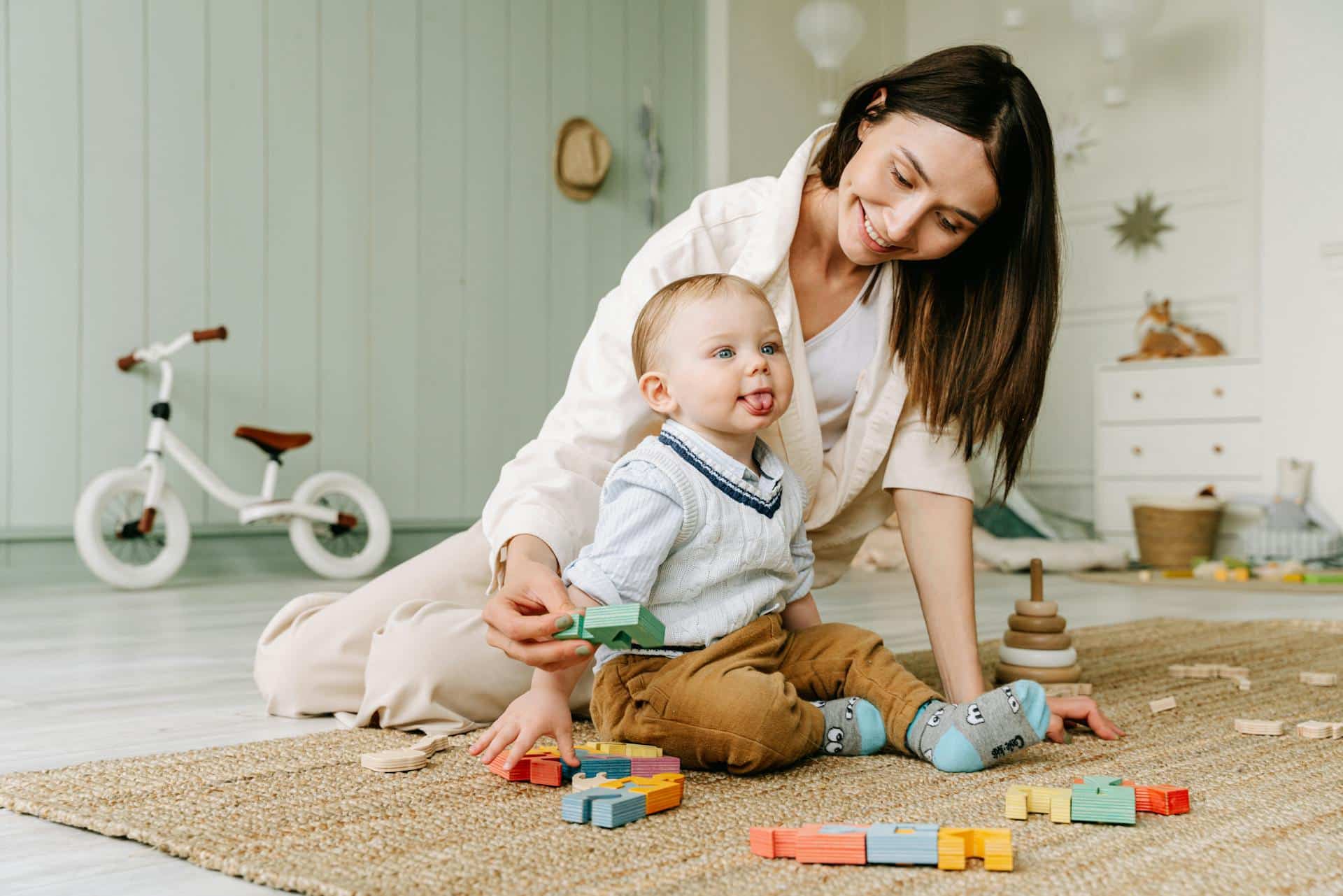 Infant and mother playing with colored toy blocks