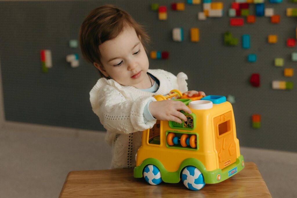 Toddler playing with a toy truck.